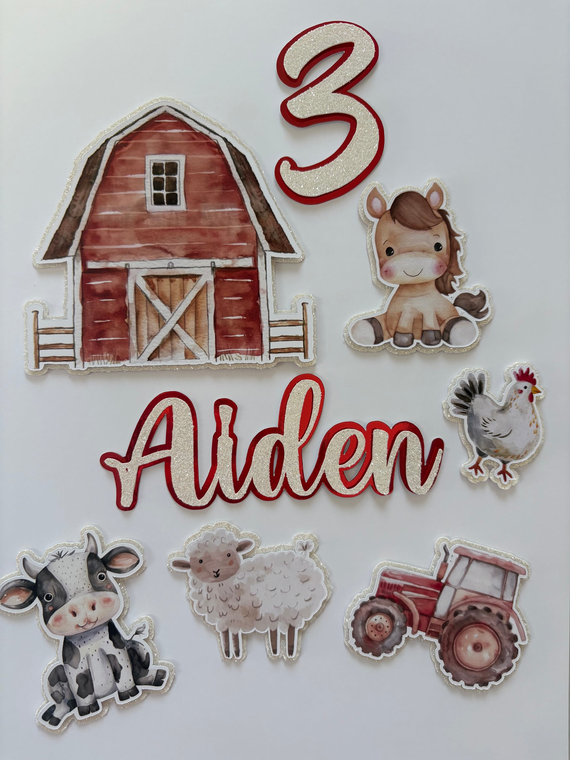 A set of personalized farm-themed paper cutouts on a white background, featuring a red barn, a brown horse, a rooster, a cow, a sheep, a red tractor, the number 3, and the name 'Aiden' in red script.