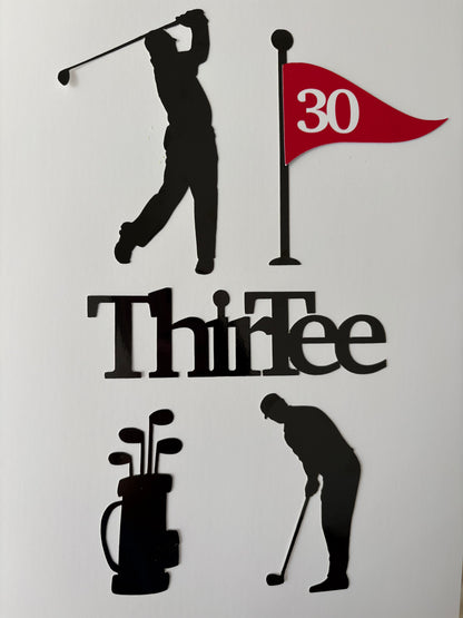 Golf-themed wall decor featuring black silhouette cutouts of a golfer, a flag with a red '30' and black pole, the word 'ThirTee' in black, a black golf bag with clubs, and another golfer silhouette, all arranged on a plain white background.